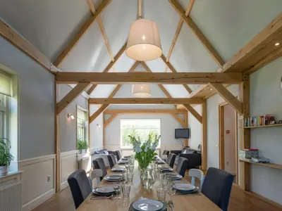a long dining room with a long table and chairs at Haven with Garden & Comfort in Zuidoostbeemster