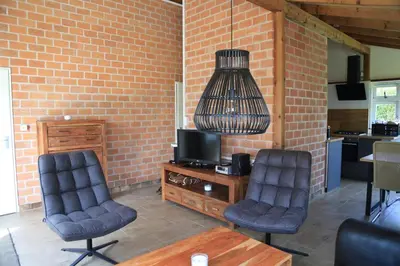 a living room with two chairs and a television at Rekerlanden 98 in Schoorldam