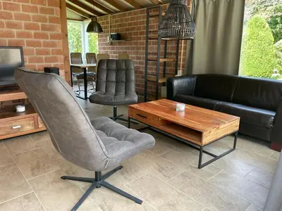 a living room with a couch and a table and chairs at Rekerlanden 98 in Schoorldam