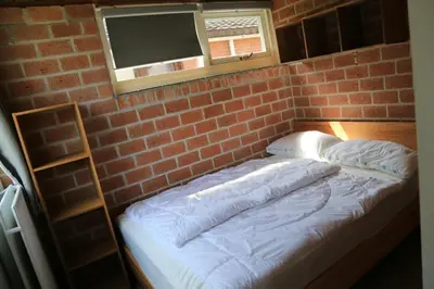 a brick wall with a bed in a room at Rekerlanden 98 in Schoorldam