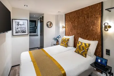 a bedroom with a large bed with yellow and white pillows at Sotel Amsterdam Central Station in Amsterdam