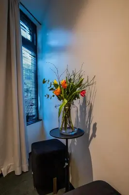 a vase of flowers sitting on a table next to a window at Sotel Amsterdam Central Station in Amsterdam