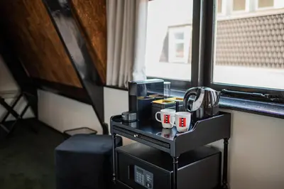 a table with mugs on it next to a window at Sotel Amsterdam Central Station in Amsterdam