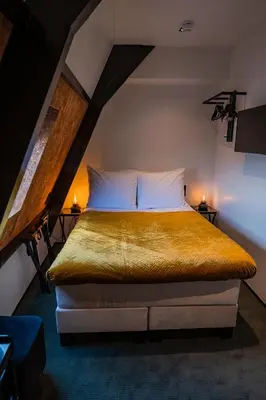 a bedroom with a large bed in a attic at Sotel Amsterdam Central Station in Amsterdam