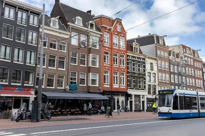 a bus driving down a city street with buildings at Sotel Amsterdam Central Station in Amsterdam