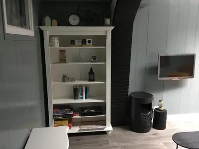 a white book shelf with a tv in a room at B&B Alkmaars Toppunt XL in Alkmaar