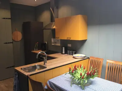 a kitchen with a table and a sink and a counter top at B&B Alkmaars Toppunt XL in Alkmaar