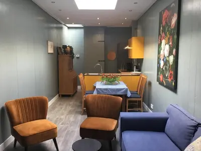 a dining room with a table and a blue couch at B&B Alkmaars Toppunt XL in Alkmaar