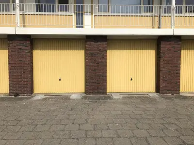 two yellow garage doors in front of a building at SEA MORE in Zandvoort