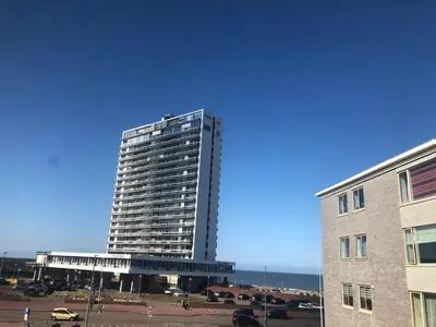 a tall building in front of a parking lot at SEA MORE in Zandvoort
