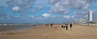 a group of people walking on the beach at SEA MORE in Zandvoort