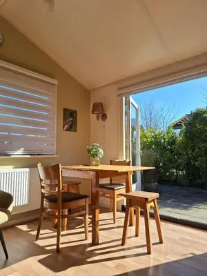 a dining room with a wooden table and chairs at Rekerlanden 257 in Schoorldam