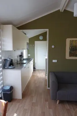 a kitchen with a couch and a counter top at Rekerlanden 257 in Schoorldam