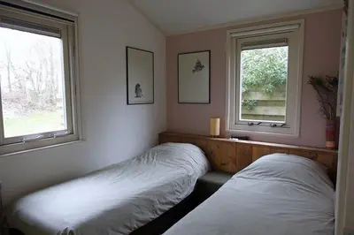 two beds in a room with two windows at Rekerlanden 257 in Schoorldam