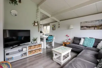 a living room with a couch and a tv and a table at Rekerlanden 195 in Schoorldam