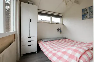 a small bedroom with a bed and a window at Rekerlanden 195 in Schoorldam