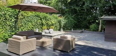 a patio with three chairs and an umbrella at Lake House 74, luxury accommodation ir Sauna in Warmond