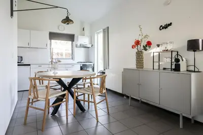 a kitchen with white cabinets and a table and chairs at Zilt vakantiehuisje - Rekerlanden 283 in Schoorldam