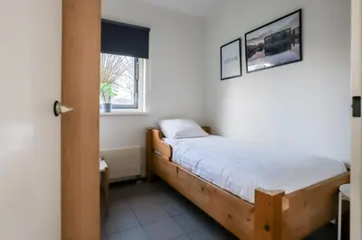a small bedroom with a bed and a window at Zilt vakantiehuisje - Rekerlanden 283 in Schoorldam