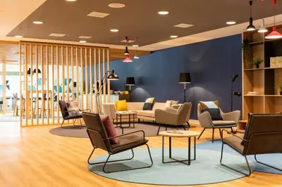 a lobby with chairs and couches and tables at Holiday Inn Express Amsterdam - North Riverside by IHG in Amsterdam