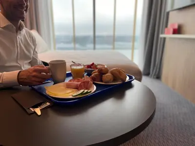 a man sitting at a table with a tray of food at Holiday Inn Express Amsterdam - North Riverside by IHG in Amsterdam