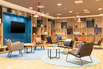 a waiting room with chairs and a flat screen tv at Holiday Inn Express Amsterdam - North Riverside by IHG in Amsterdam