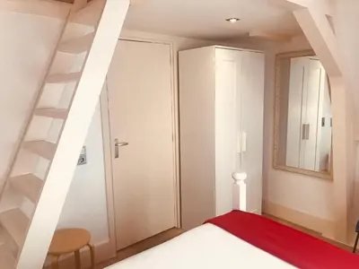 a bedroom with a staircase and a red rug at Little Tulip in Amsterdam