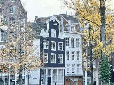a blue and white house in front of buildings at Little Tulip in Amsterdam