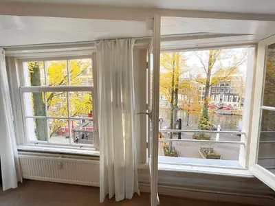 a room with two large windows with white curtains at Little Tulip in Amsterdam