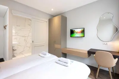 a bedroom with a bed and a desk and a mirror at Anegang Boutique Hotel in Haarlem