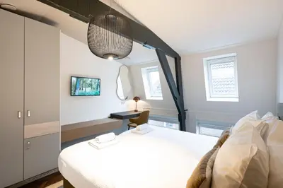 a bedroom with a large white bed and a lamp at Anegang Boutique Hotel in Haarlem