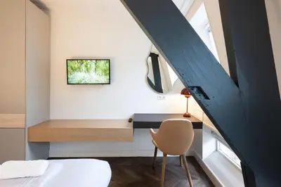 a bedroom with a bed and a desk with a chair at Anegang Boutique Hotel in Haarlem