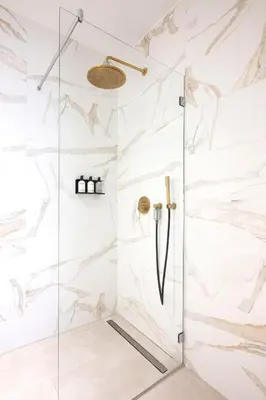 a shower with white marble walls and a glass door at Anegang Boutique Hotel in Haarlem