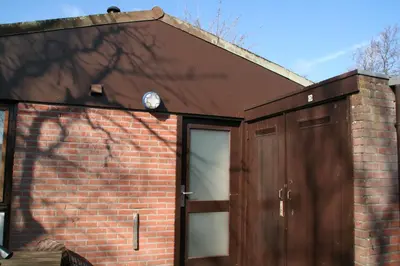 a brick house with a door and a brick wall at Rekerlanden 173 in Schoorldam