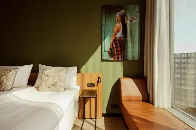 a bedroom with a bed and a picture of a woman at Van der Valk Hotel Amsterdam Zuidas-Rai in Amsterdam