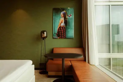 a room with a table and a picture of a woman at Van der Valk Hotel Amsterdam Zuidas-Rai in Amsterdam