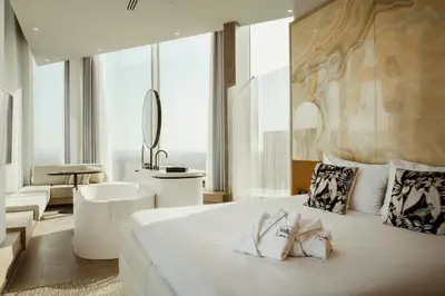 a bedroom with a large white bed and a bathroom at Van der Valk Hotel Amsterdam Zuidas-Rai in Amsterdam