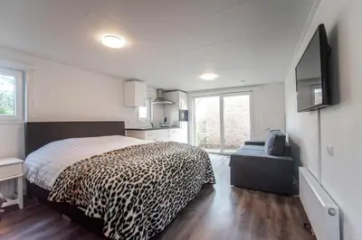 a bedroom with a bed with a leopard print blanket at Studio the Dunes in Zandvoort