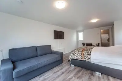 a bedroom with a bed and a blue couch at Studio the Dunes in Zandvoort