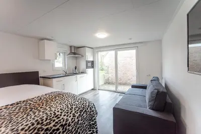 a bedroom with a leopard print bed and a couch at Studio the Dunes in Zandvoort