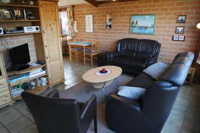 a living room with black leather furniture and a table at Rekerlanden 161 in Schoorldam