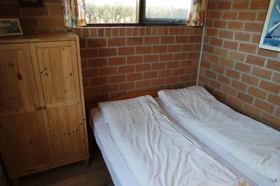 a bed in a room with a brick wall at Rekerlanden 161 in Schoorldam