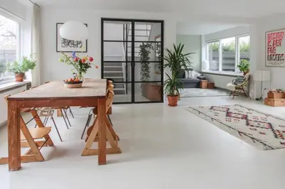 a living room with a wooden table and chairs at Vakantiehuis Drie Dennen in Bergen