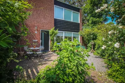a brick house with a garden in front of it at Vakantiehuis Drie Dennen in Bergen