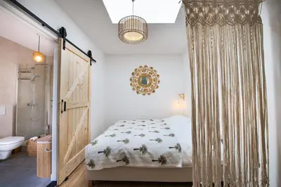 a bedroom with a bed and a shower at Sea Cottage Zandvoort in Zandvoort