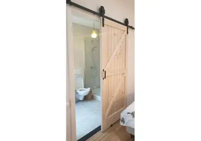 a sliding door leading to a bathroom with a toilet at Sea Cottage Zandvoort in Zandvoort