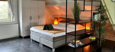a bedroom with a bed and a book shelf at De Weideblom in Schermerhorn