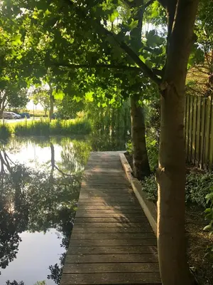 a wooden bridge over a body of water at De Weideblom in Schermerhorn