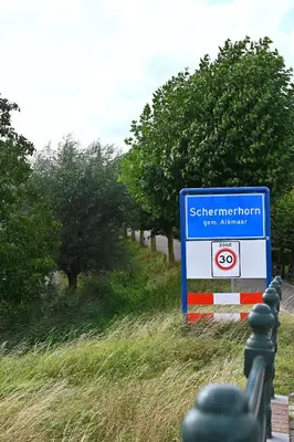 a sign on the side of a road with trees at De Weideblom in Schermerhorn