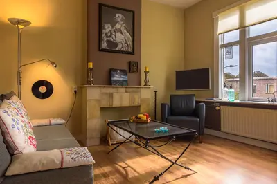 a living room with a couch and a fireplace at Familie Quellhorst in Leiden